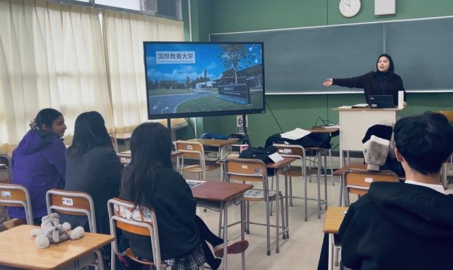 教壇でスライドとともに講演する先輩と聞き入るESSメンバー