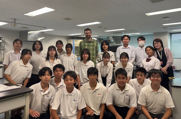 講師と教諭、高校生、大学生たちで記念撮影