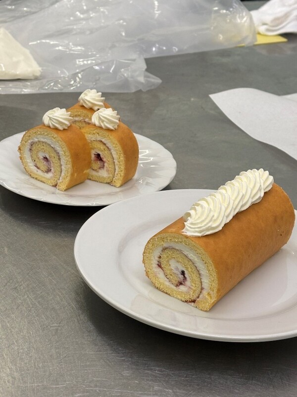 きつね色に焼けて白いクリームを巻いたロールケーキ