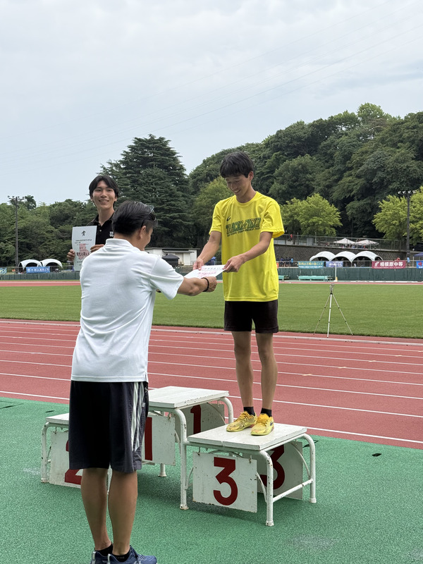 表彰台で3位入賞の賞状をもらう陸上競技部員1