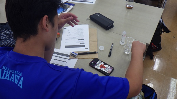 室内で実験をする生徒