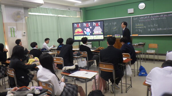 黒板に英文を書き電子黒板に単語の意味の画像を表示させる様子