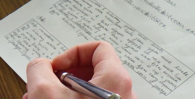 案内文を書く生徒の手元