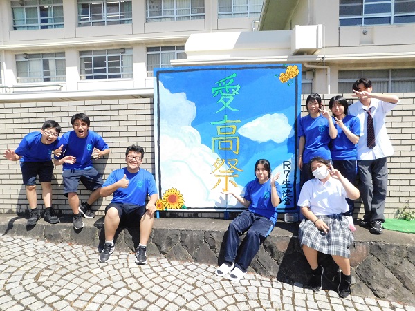 入口の看板には青空に白い雲の背景に「愛高祭」
