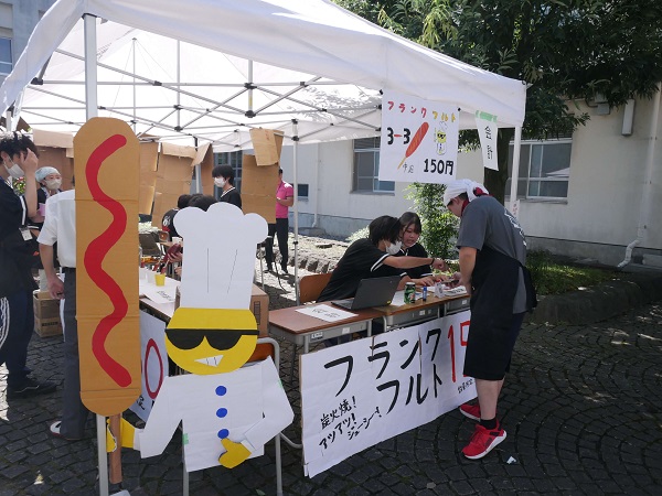 にやりと笑ったキャラクターの看板がかわいい模擬店