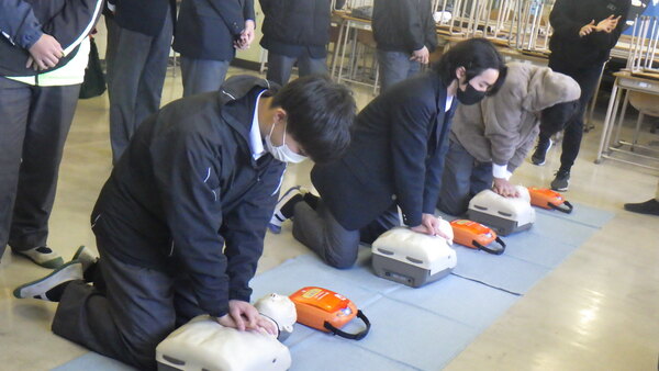 並んで練習器具に向かい胸骨圧迫をする生徒たち