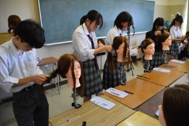 美容師体験で髪をスタイリングする生徒たち