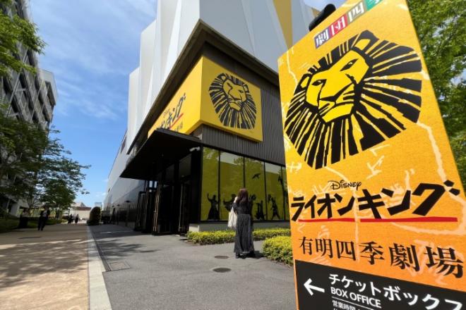 劇場入り口にはライオンキングの黄色い大きな看板があり、生徒は写真を撮っていました。