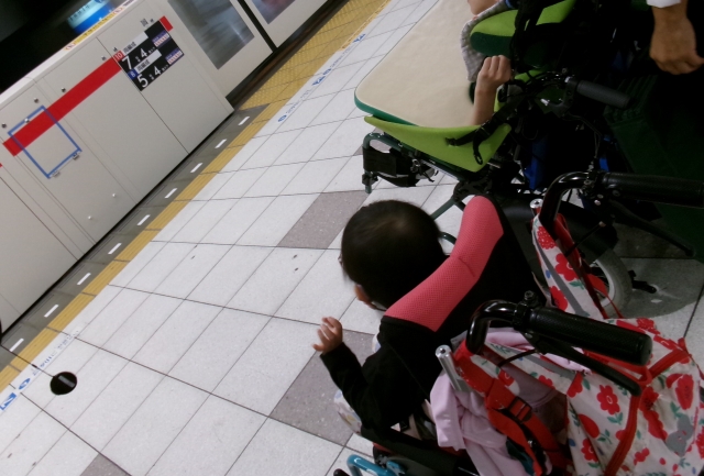 駅のホームで電車を待っているところ
