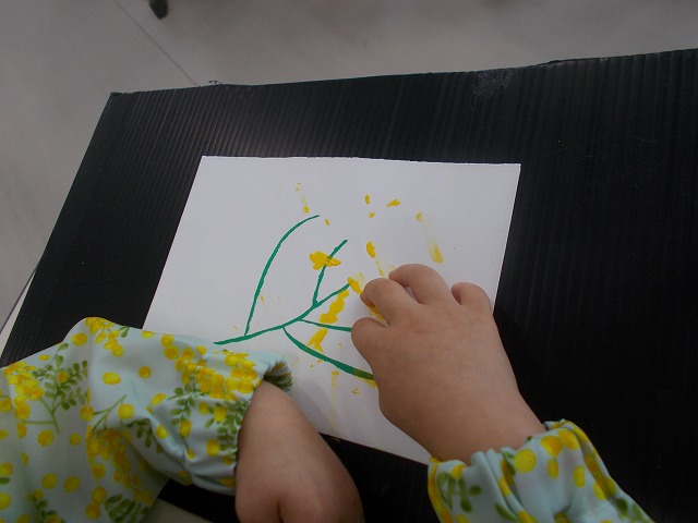 指絵の具でミモザを表現している